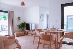 a living room with a dining room table and chairs at Mar-Ria 7 in Fuzeta