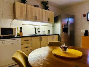 cocina con mesa de madera con sillas y nevera en Iepurasul Sinaia, en Sinaia