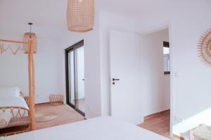 a room with a bed and a hallway with a mirror at Mar-Ria 7 in Fuzeta