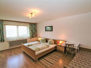 sypialnia z łóżkiem, biurkiem i stołem w obiekcie Apartment Jägerhof-1 by Interhome w mieście Hochpillberg