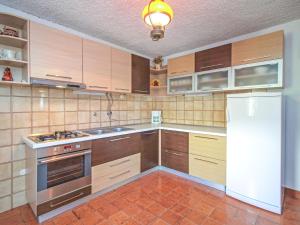 una cucina con mobili in legno e un frigorifero bianco di Holiday Home Karmela by Interhome a Vodice