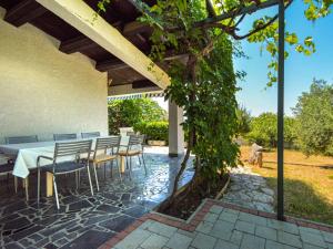 un patio con tavolo e sedie sotto un edificio di Holiday Home Karmela by Interhome a Vodice