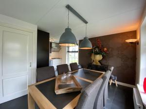 eine Küche und ein Esszimmer mit Tisch und Stühlen in der Unterkunft Holiday Home Wiringherlant-6 by Interhome in Noordstroe