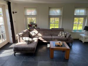 a living room with a couch and a coffee table at Holiday Home Wiringherlant-6 by Interhome in Noordstroe