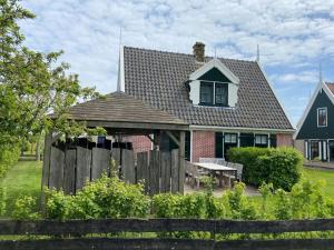 a house with a wooden fence in front of it at Holiday Home Wiringherlant-6 by Interhome in Noordstroe