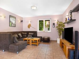 a living room with a couch and a tv at Villa Smeraldo by Interhome in Balatonszabadi Fürdőtelep