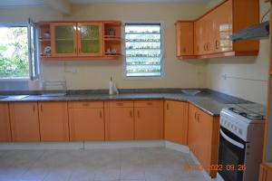 a kitchen with orange cabinets and a stove top oven at Villa nana in Pointe-Noire