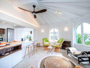 a kitchen with green chairs and a ceiling fan at Holiday Home Villa Sol by Interhome in Calpe