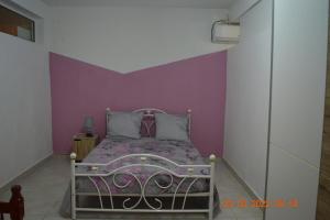 a bedroom with a bed with a purple wall at Villa nana in Pointe-Noire