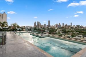 a swimming pool with a city skyline in the background at Boho retreat near The Gabba with stunning views in Brisbane
