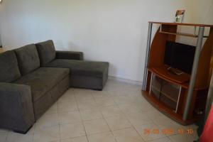 a living room with a couch and a tv at Villa nana in Pointe-Noire