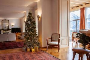 a christmas tree in the middle of a living room at Luxury Apartment, Panoramic Mountain Views, 5 Star Spa Facilities - 3 Bedroom in Chateau-d'Oex