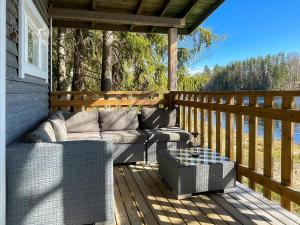 eine Terrasse mit einem Sofa auf einer Holzterrasse in der Unterkunft Holiday Home Lepola by Interhome in Vaskivesi