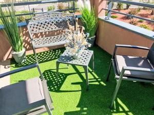 a balcony with a chair and a table and chairs at Apartment Le Jardin du Loderi-1 by Interhome in Bormes-les-Mimosas