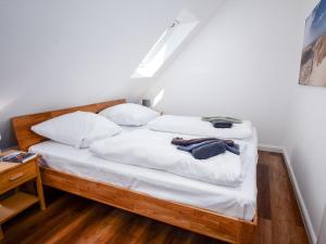 een bed met witte lakens en kussens in een kamer bij Apartment Scholle by Interhome in Norddeich