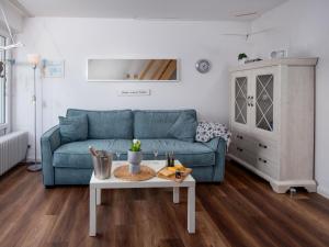 een woonkamer met een blauwe bank en een tafel bij Apartment Scholle by Interhome in Norddeich
