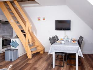 een eetkamer met een tafel met stoelen en een trap bij Apartment Scholle by Interhome in Norddeich +32 foto's