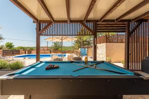 a pool table in a pavilion with a swimming pool at Holiday Home Burgija with pool in Benkovac