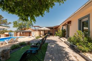 a row of benches in front of a house at Holiday Home Burgija with pool in Benkovac
