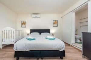 a bedroom with a large bed and a crib at Holiday Home Burgija with pool in Benkovac +62 photos