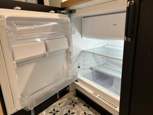 an empty refrigerator with its door open in a kitchen at l'escale in Trouville-sur-Mer