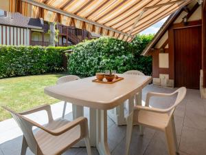 a white table and chairs sitting on a patio at Holiday Home Domaine de Clairefontaine-2 by Interhome in Deauville