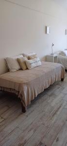 a bed with pillows on it in a white room at FerPilar Suite, Concord Pilar in Pilar