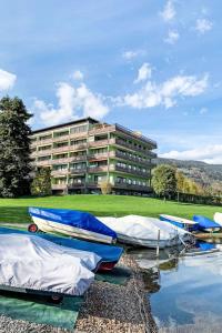a building with boats in the water in front of a building at Apartment Seezugang & Ski Ossiacher See by Interhome in Bodensdorf