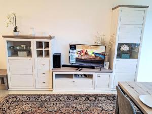 a large white entertainment center with a flat screen tv at Apartment Seezugang & Ski Ossiacher See by Interhome in Bodensdorf