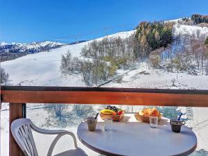 a table with a bowl of fruit on a snow covered mountain at Studio Soyouz Vanguard-102 by Interhome in Le Corbier