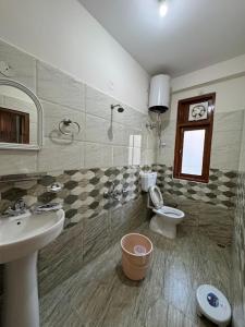 a bathroom with a sink and a toilet at KK Homestay Bhuntar - By Soma Stays in Shamshi