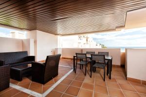 a dining room with black chairs and a table at Estepona East Apartment MAEWEST in Estepona