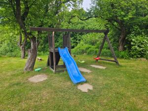 a playground with a blue slide in a park at Klimat Sadu Noclegi in Jaśkowice