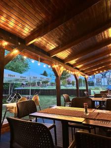 een terras met tafels en stoelen onder een houten pergola bij Noclegi Primavera in Jaśkowice
