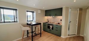 a kitchen with green cabinets and a small table at Morgensolen in Bergen +4 photos