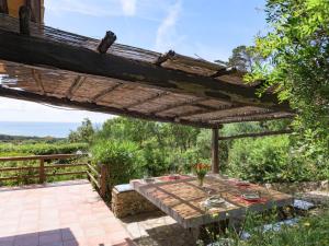 un patio avec une table sous une pergola en bois dans l'établissement Holiday Home La Tagliata by Interhome, à Ansedonia