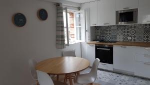 a kitchen with a wooden table and white cabinets at L'escapade in Trouville-sur-Mer +6 photos