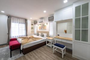 une chambre avec un grand lit et une chaise rouge dans l'établissement LakeLyn Pool Villa 5BR , Free daily housekeeping, à Chiang Mai