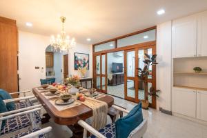 une salle à manger et un salon avec une table et des chaises dans l'établissement LakeLyn Pool Villa 5BR , Free daily housekeeping, à Chiang Mai