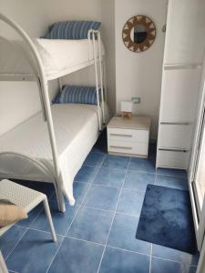 una camera da letto con un letto a castello e un pavimento in piastrelle blu di L' Azzurro Mare casa vacanze a Pozzallo