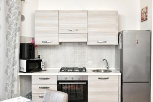 a small kitchen with a refrigerator and a sink at Perla Apartment con vista mare in Olbia