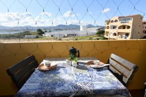 a table with two chairs and a view of the ocean at Perla Apartment con vista mare in Olbia