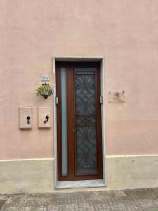 una porta sul lato di un edificio rosa di Domus Olea & Opuntia Salento a Galatone