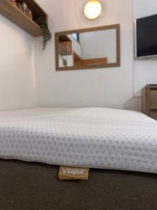 a bedroom with a white bed and a mirror at Apartma Izola in Izola