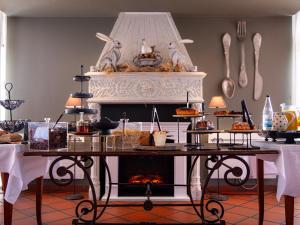 a table with food on it with a fireplace at Hôtel Restaurant Verger des Châteaux, Route des vins Haut-Koenigsbourg in Dieffenthal