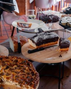 a person reaching for a slice of cake on a table at Hôtel Restaurant Verger des Châteaux, Route des vins Haut-Koenigsbourg in Dieffenthal
