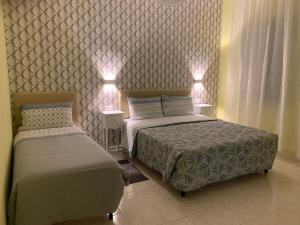 two beds in a bedroom with lights on the wall at Ca' Rosso Venice in Venice