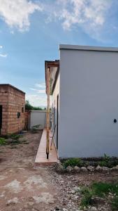 een grote witte muur naast een gebouw bij The one room in Mto wa Mbu