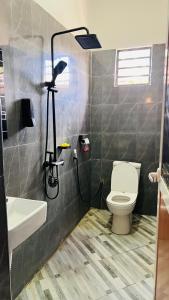 een badkamer met een wit toilet en een wastafel bij The one room in Mto wa Mbu