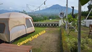 a tent sitting on the grass in a field at Crazy Steak Resort Glamping Villa Resto 24h in Batu